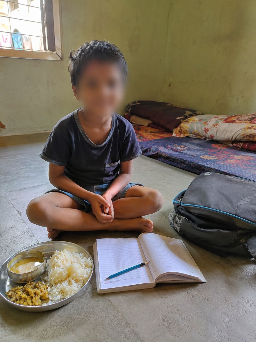 Aarav studying on the floor, meal beside his notebook